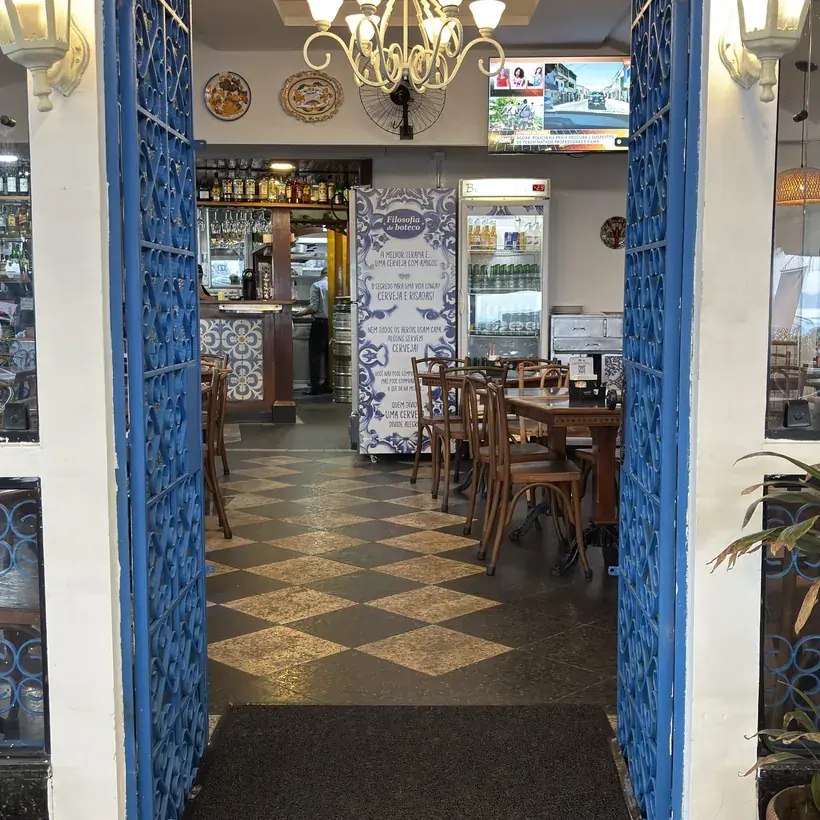 Entrada do salão do Hera Bar e Botequim, com piso quadriculado