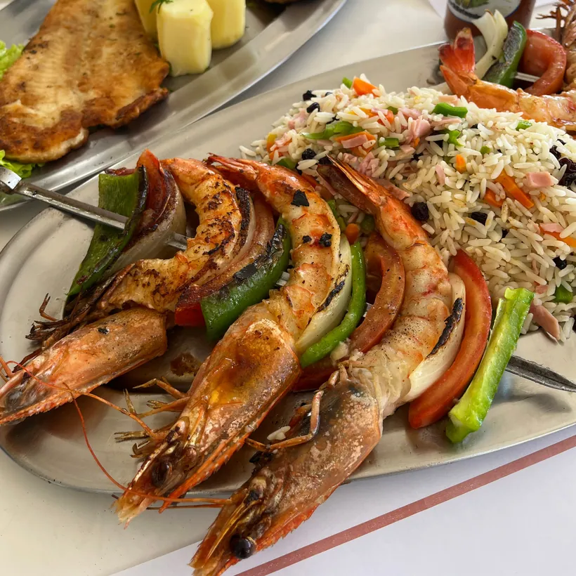 Camarões grandes grelhados servidos com arroz à grega