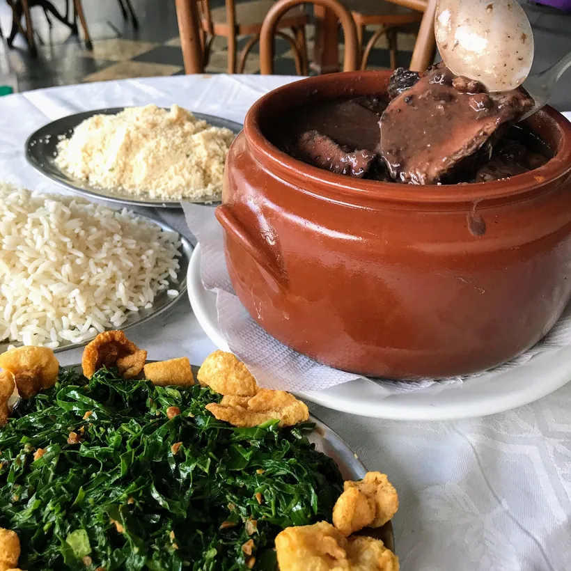 Feijoada do Hera na panela de barro com couve, arroz e farofa